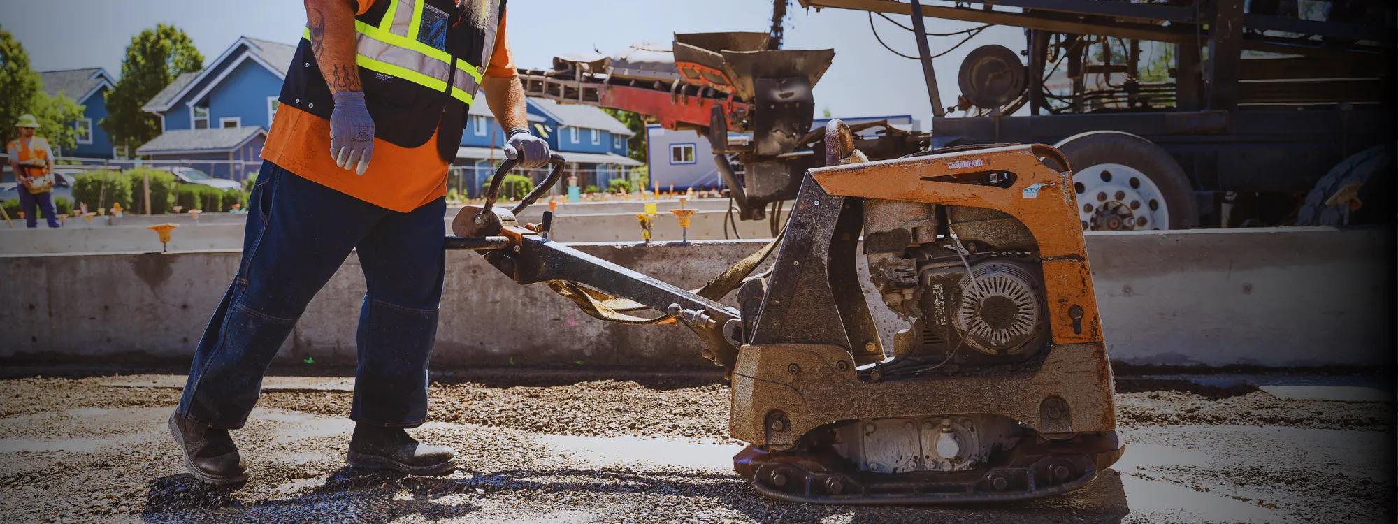 Construction worker operating equipment on a job site wearing Dickies safety footwear
